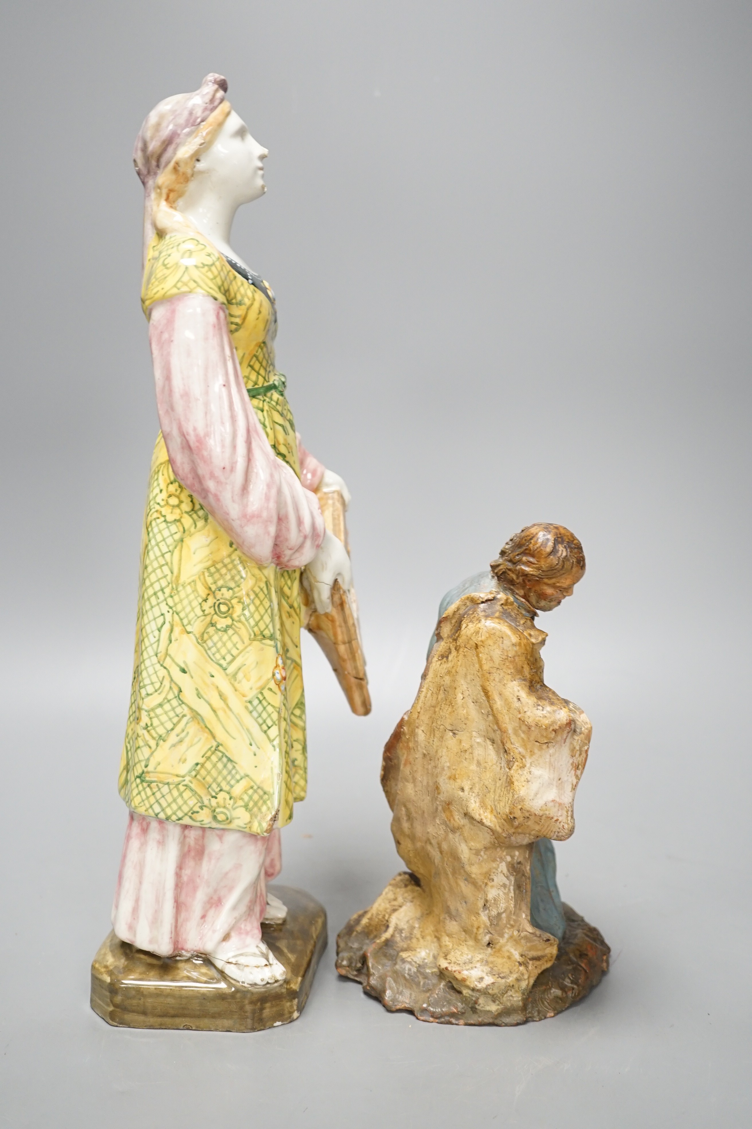 A late 19th century Italian maiolica figure of a Grecian woman or goddess with pipes and Sicilian terracotta figure of a Saint, tallest 38cm